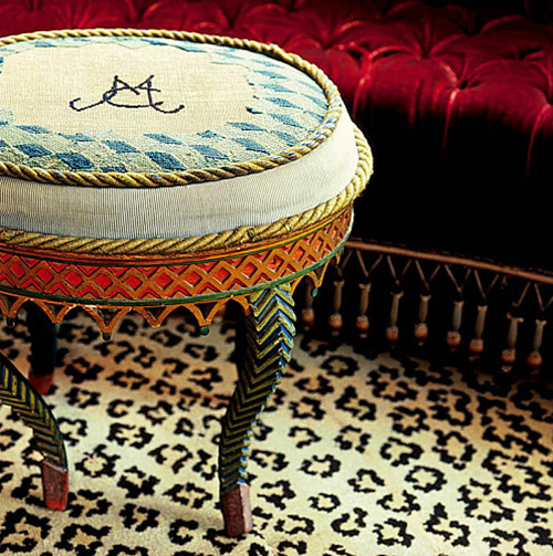 un tabouret, un morceau de canapé et un tapis au style castaing